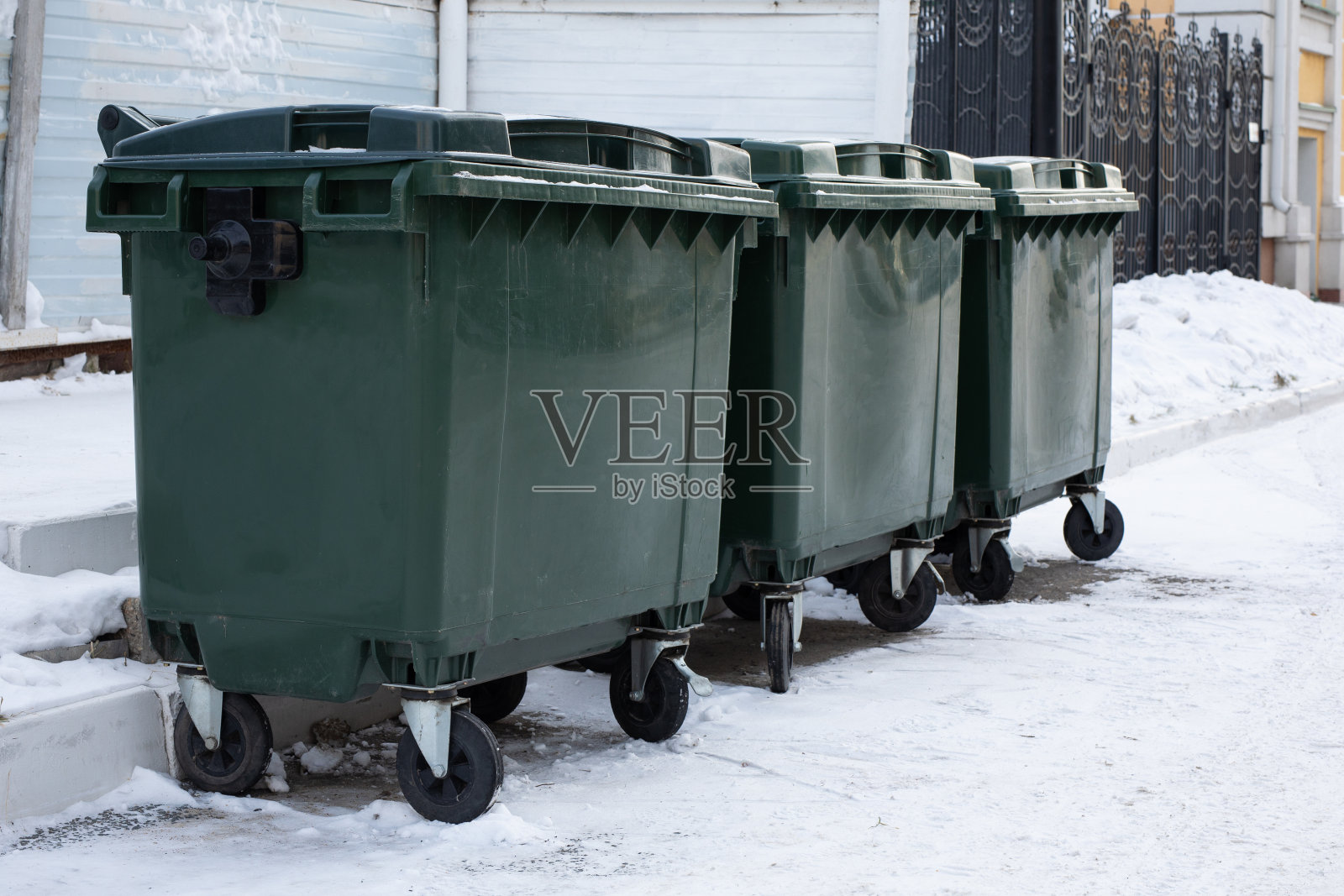 街道上堆满了被雪覆盖的垃圾容器照片摄影图片