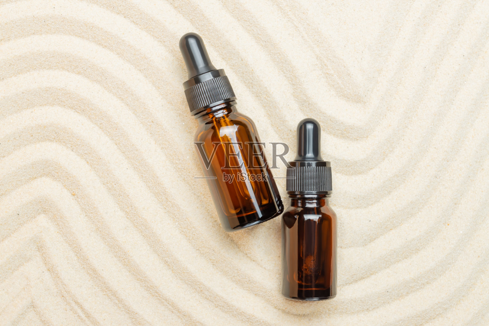 瓶的血清,油或化妆品的沙滩沙滩的背景。沙质背景的潮流产品展示照片摄影图片