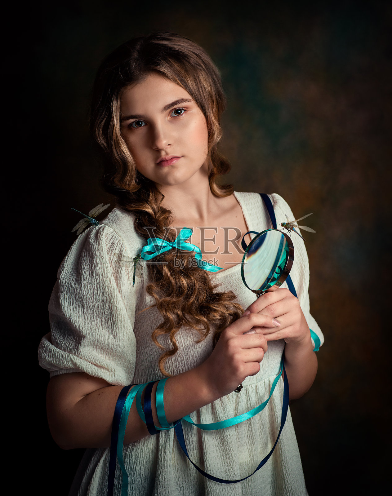 一个身穿白色连衣裙的黑发女子手里拿着一个放大镜。蜻蜓和昆虫坐在她的裙子上。
这张照片是复古风格的。照片摄影图片