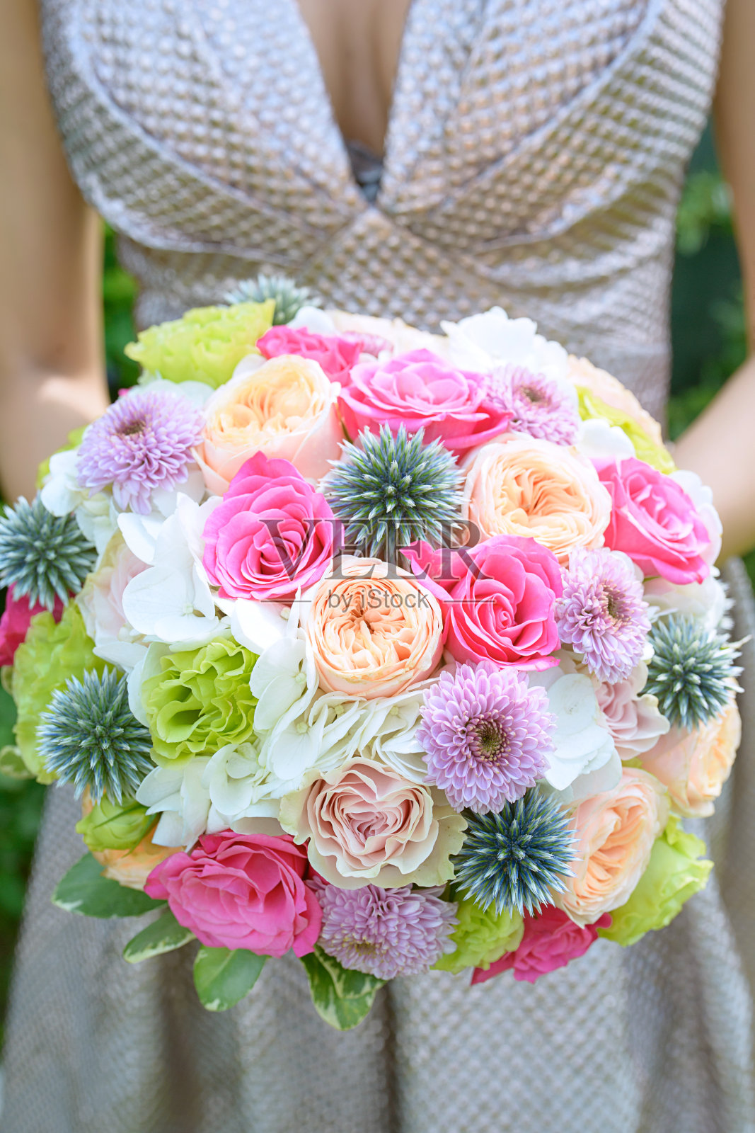 年轻女子穿着一件可爱的象牙色连衣裙,手持一束优雅的婚礼花束照片摄影图片