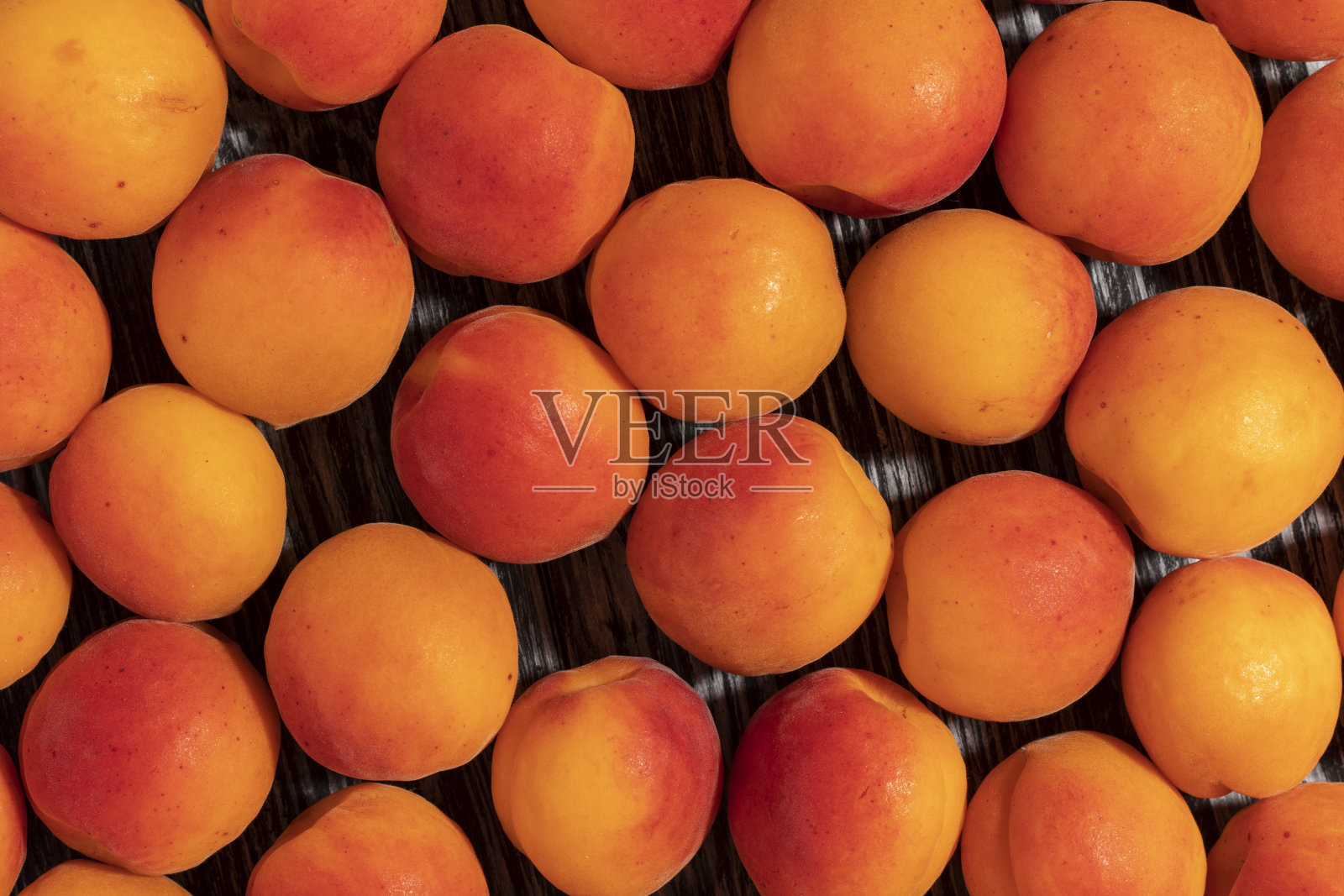 熟杏放在木桌上。照片摄影图片