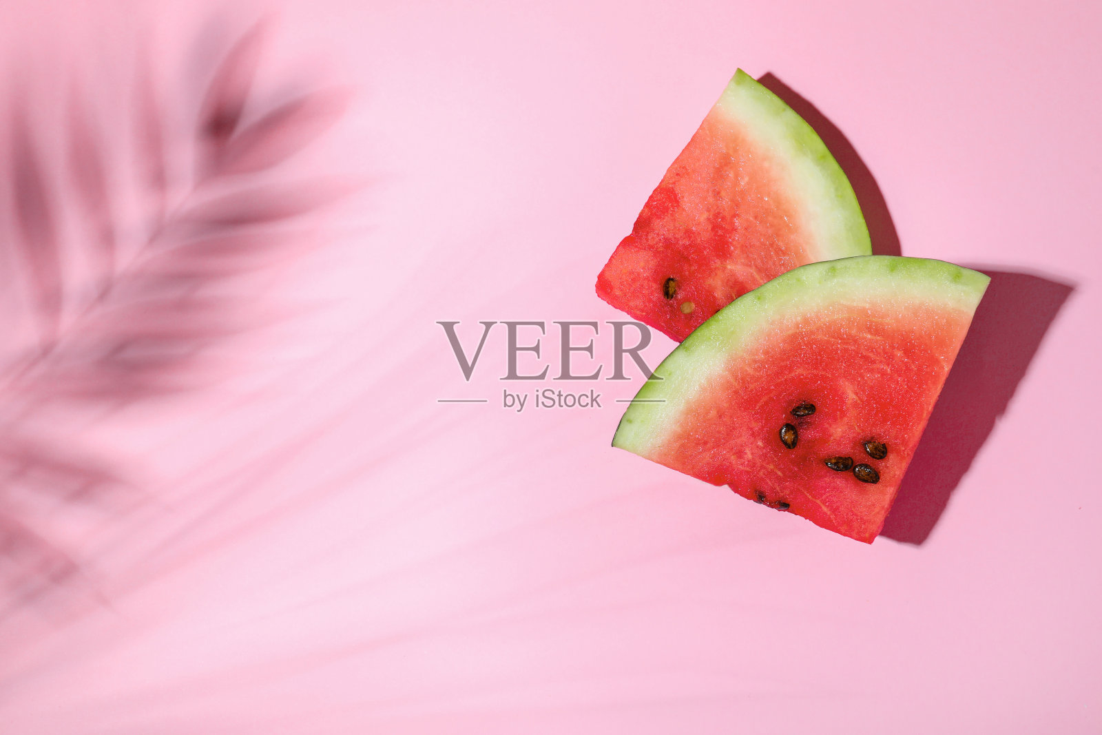 美味的成熟西瓜和热带叶影在浅粉红色的背景,平铺。空间的文本照片摄影图片