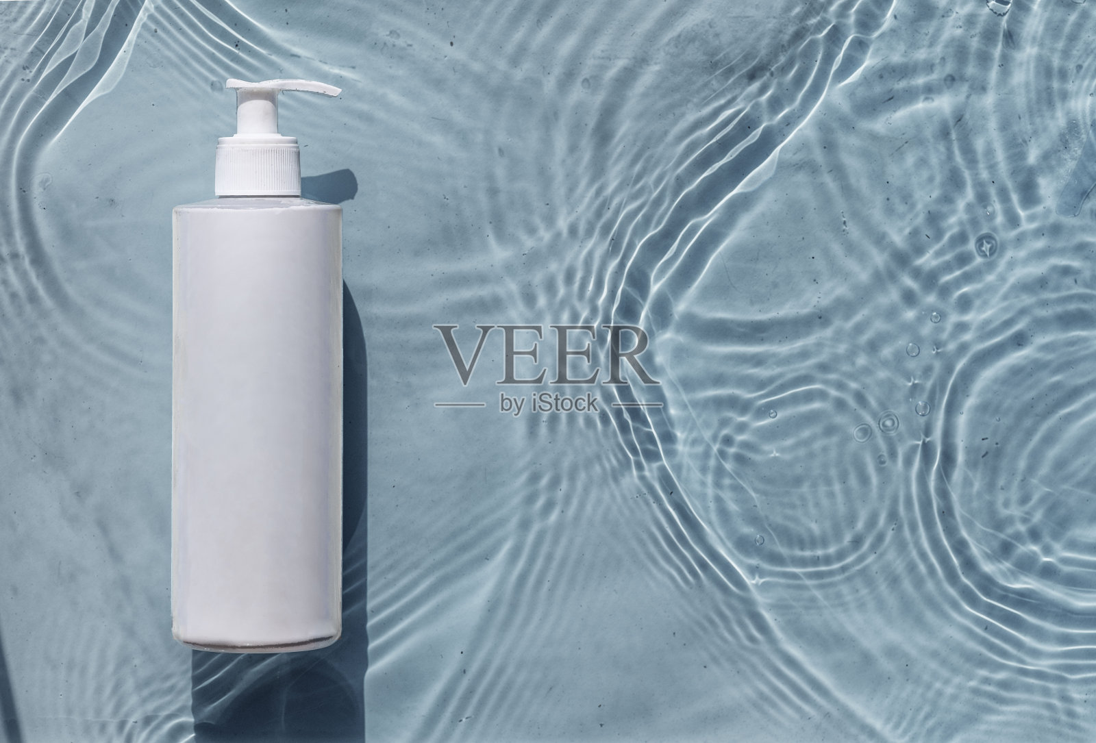 透明质酸保湿化妆品,蓝色水背景胶束乳液与飞溅。化妆品包装的模型照片摄影图片