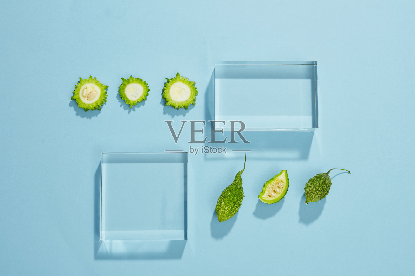 苦瓜在培养皿中的俯视图,绿叶空白蓝色背景照片摄影图片