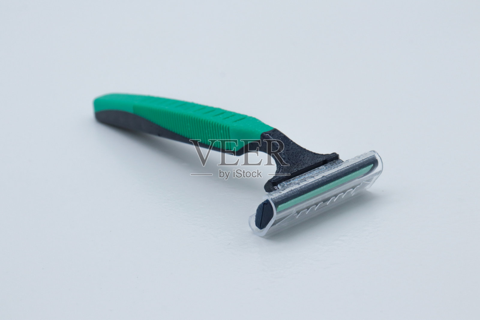 白色背景上的绿色和蓝色剃刀照片摄影图片