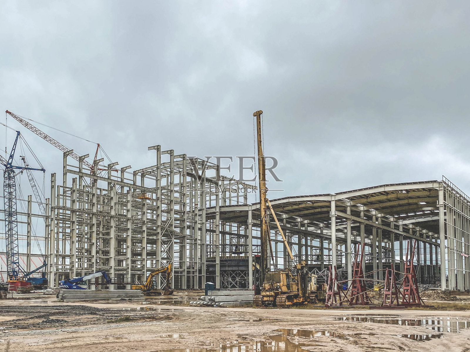 在工厂建造一个新的综合设施。用于建造地基的金属结构。黄鹤在空中运载重物照片摄影图片