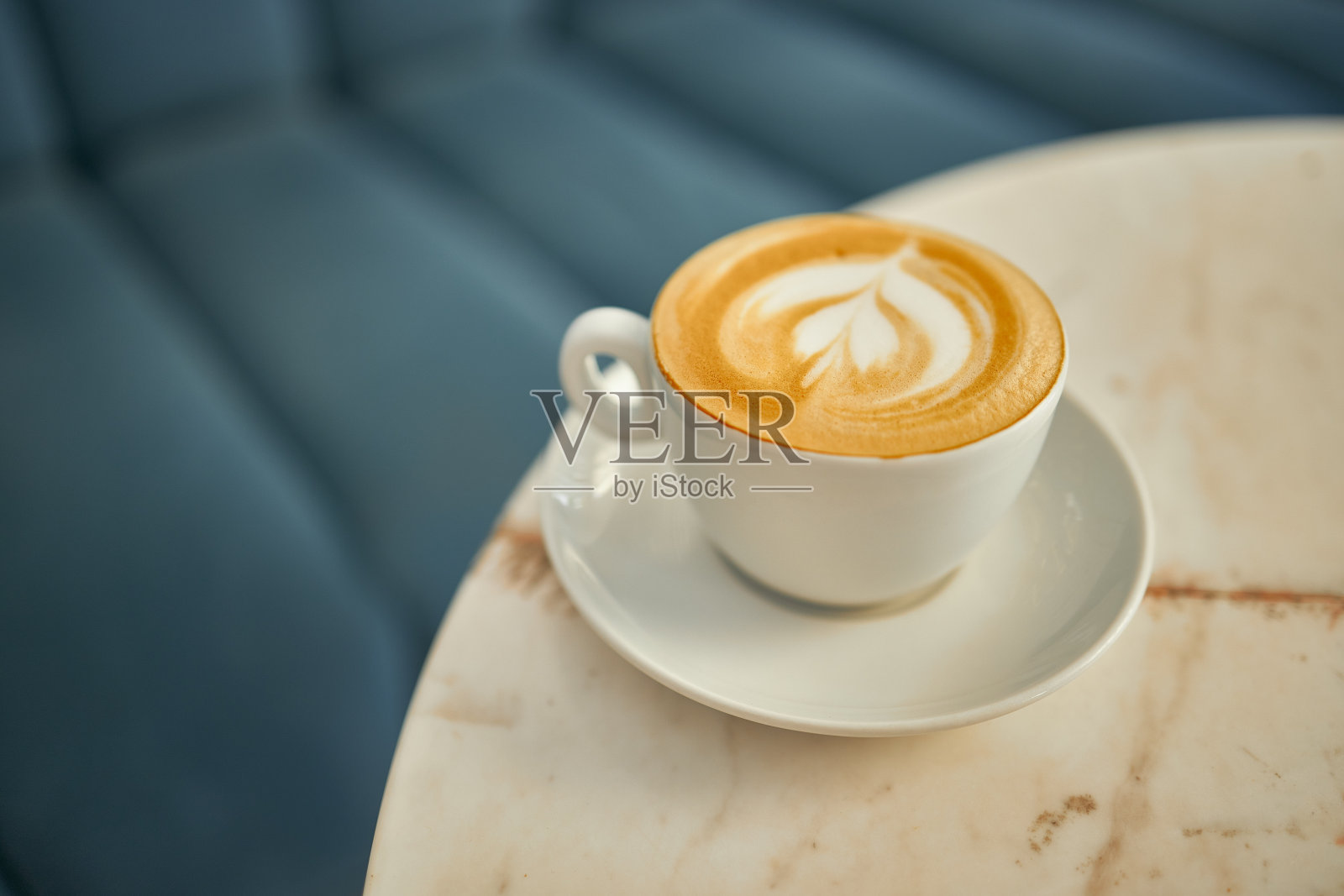 在自助餐厅的大理石桌子上放着带有泡沫的纯白色咖啡照片摄影图片