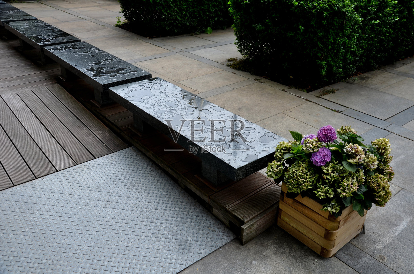 专门为轮椅改装的热带木板坡道。盲人专用金属导轨。酒店露台的保安入口。靠近抛光花岗岩板的深色长凳。照片摄影图片