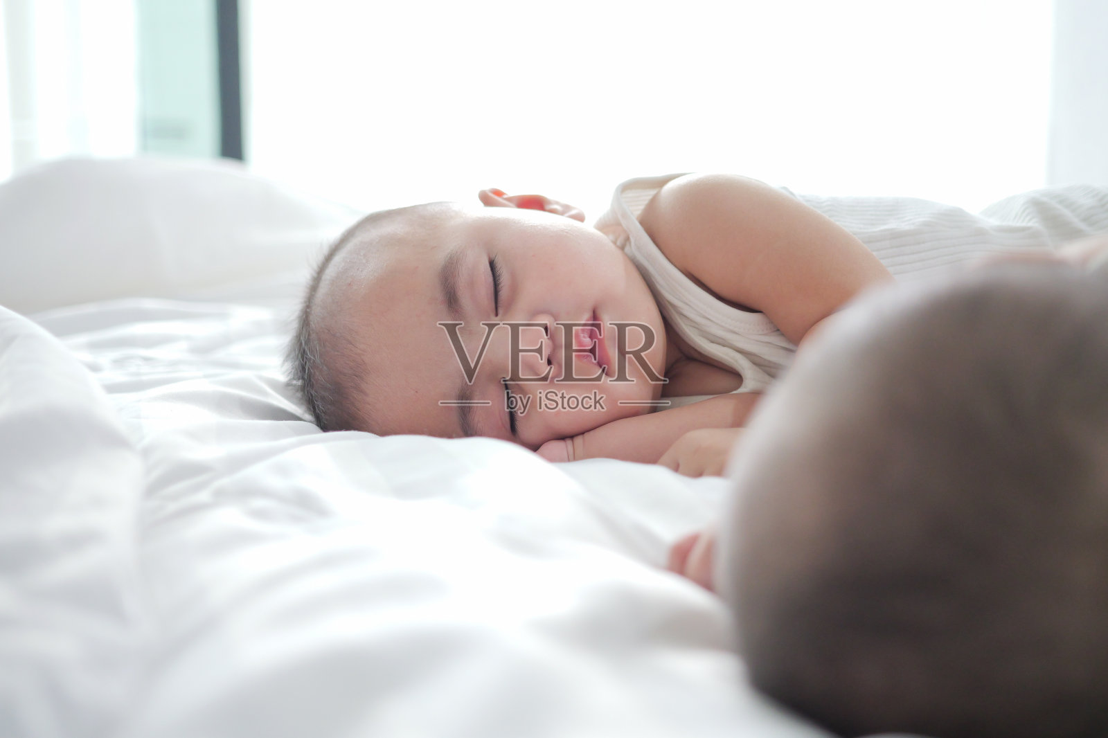 亚洲新生婴儿睡在柔软的毯子上,健康的小男孩在床上放松,婴儿睡眠的概念照片摄影图片