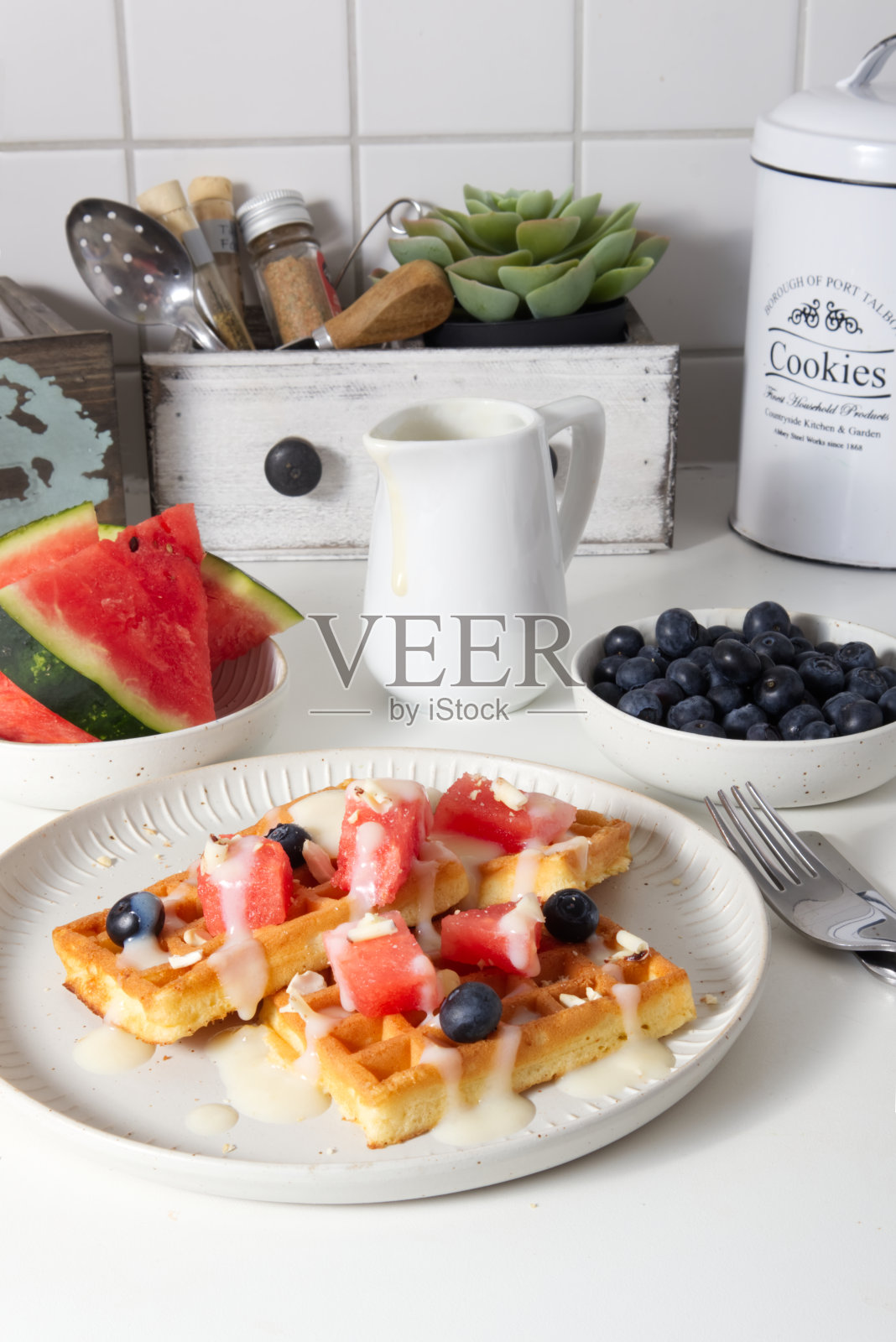 华夫饼,新鲜的西瓜和浆果,淋上奶油照片摄影图片