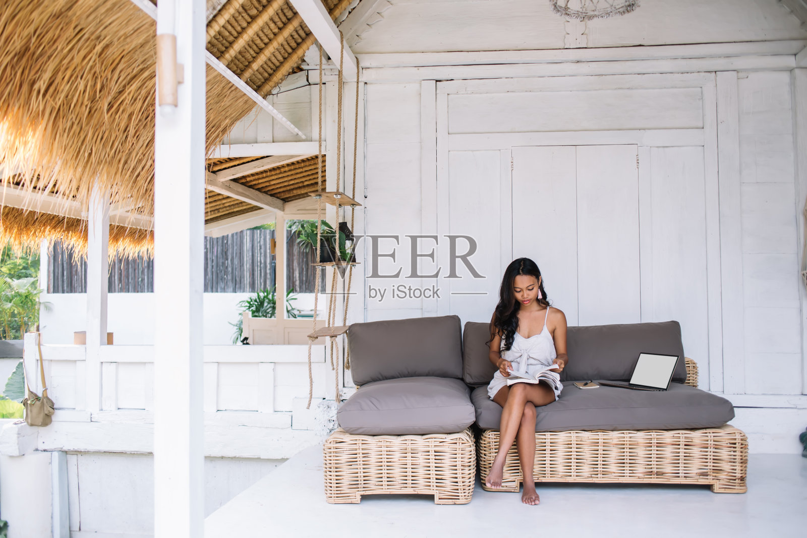 集中的少数民族自由职业者坐在沙发上做项目照片摄影图片