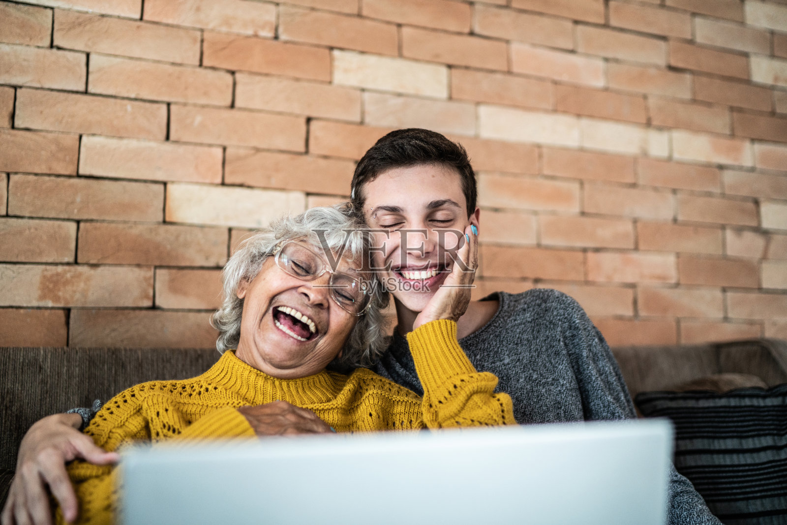 孙子和奶奶在家使用笔记本电脑照片摄影图片