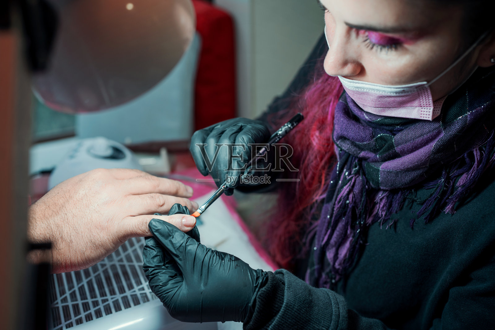 在水疗中心或美甲沙龙,美甲师在男性指甲上涂指甲油照片摄影图片