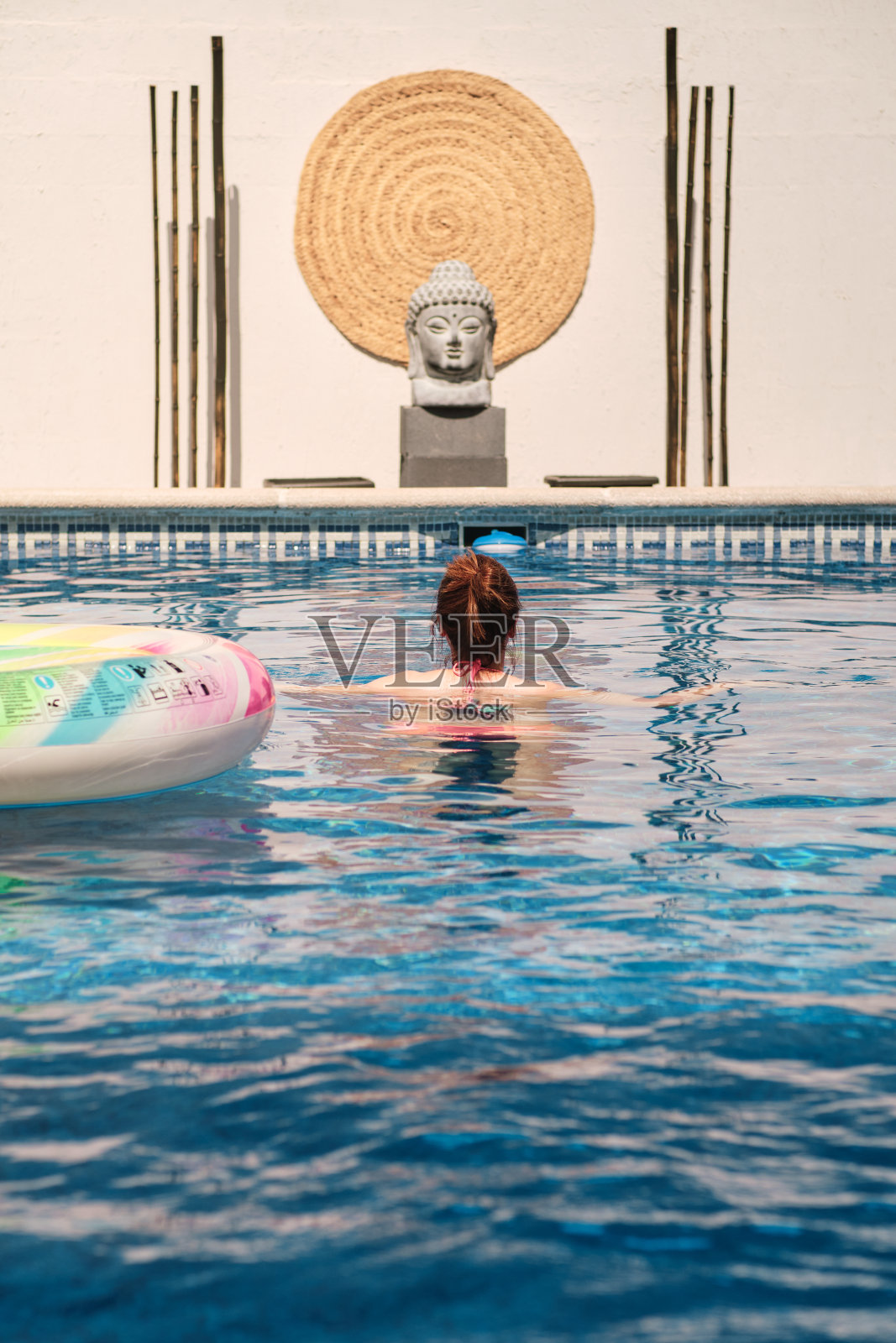 年轻的黑发女子在游泳池用垫子享受夏天照片摄影图片