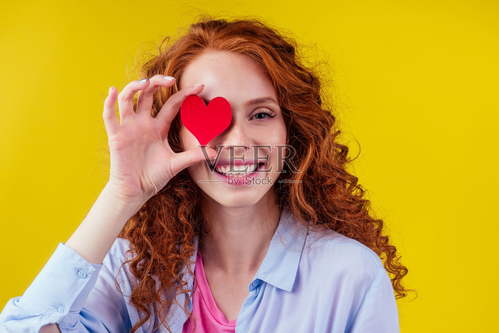 心脏病专家红发姜卷快乐的女人拿着纸在工作室黄色的背景听到照片摄影图片