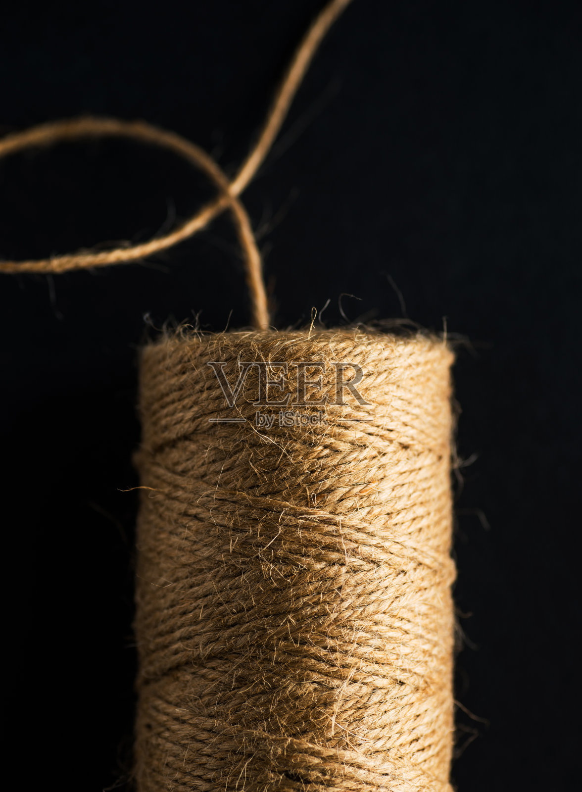 黑色背景上分离的天然黄麻麻绳束。照片摄影图片