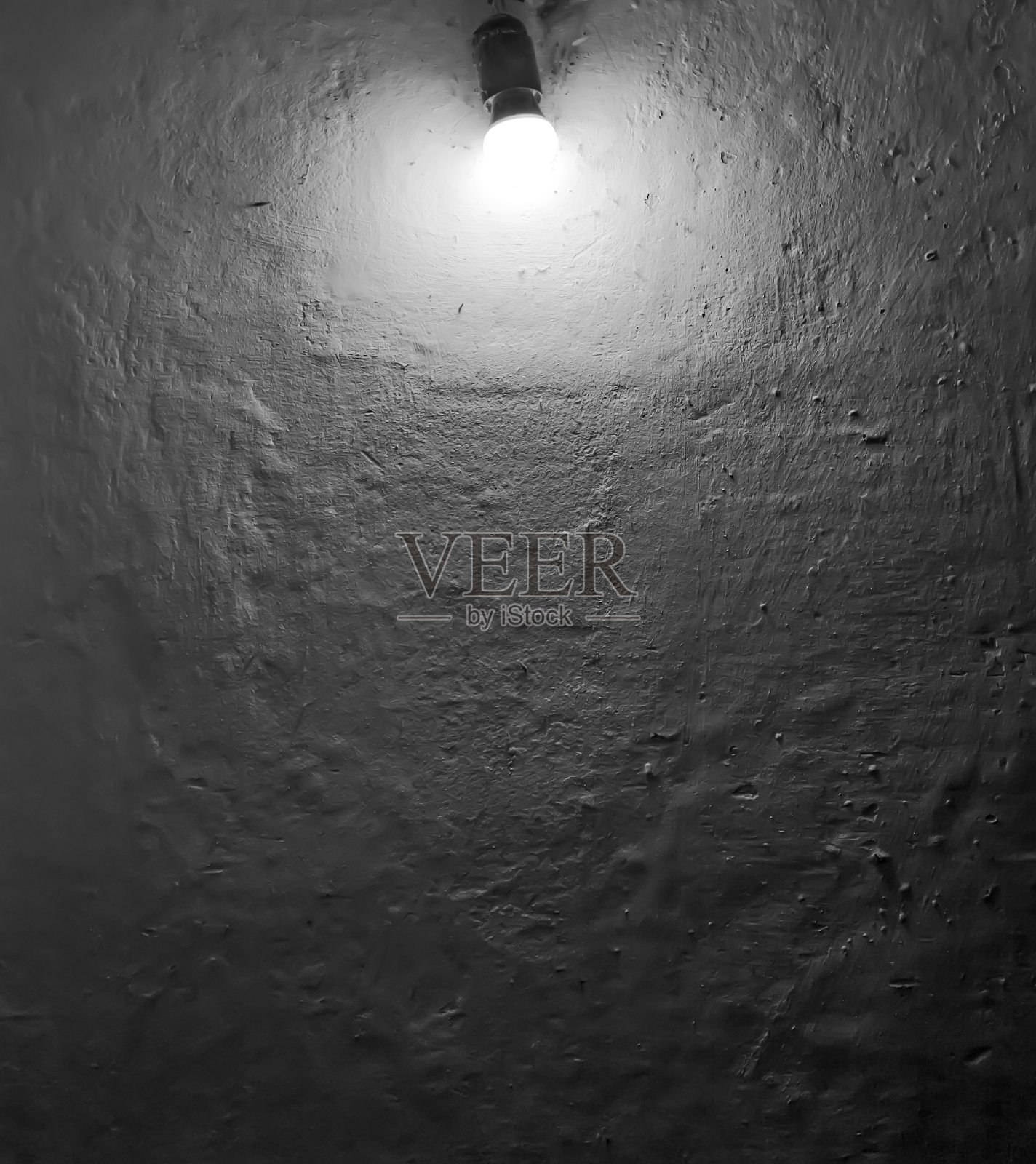 白色墙壁上的灯泡,表面凹凸不平。黑白照片与背景文字照片摄影图片