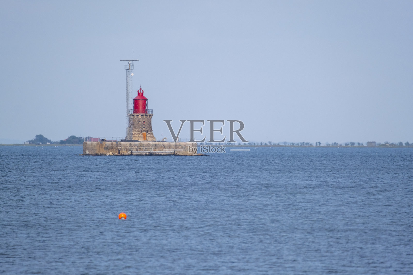 丹麦群岛上一个岩石小岛上的一个小灯塔照片摄影图片