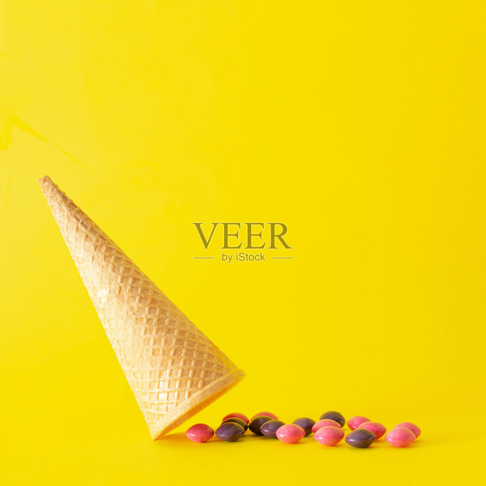 冰淇淋甜筒里面有糖果。夏天的黄色充满活力。照片摄影图片