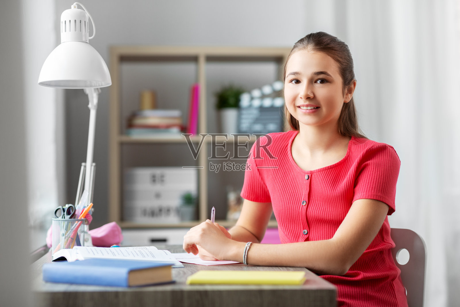 微笑的少女学生在家拿着书照片摄影图片