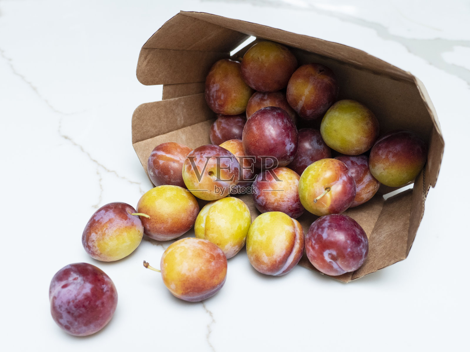 小新鲜李子装在纸盒里照片摄影图片