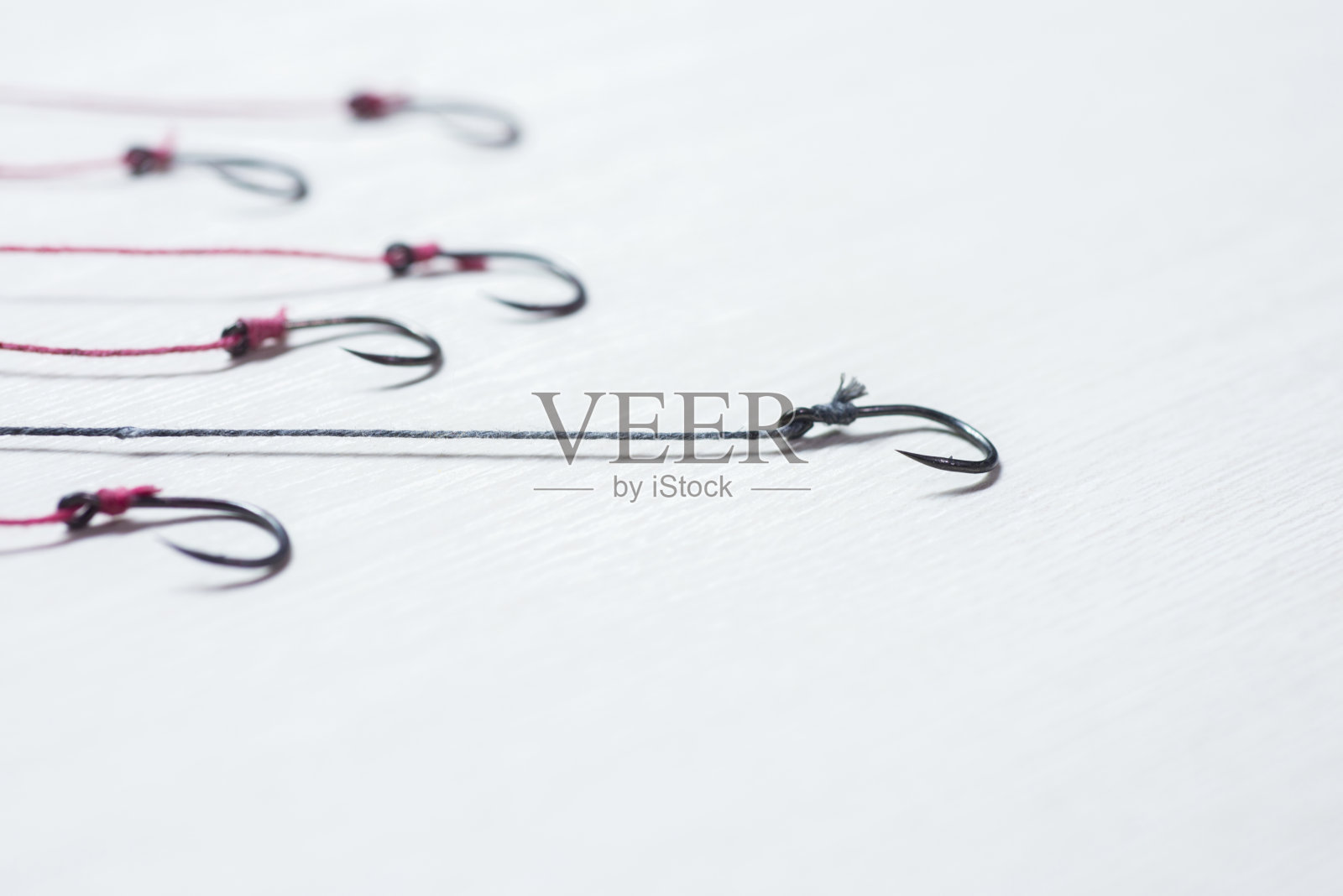 许多钓鱼钩放置在白色木地板与emp照片摄影图片