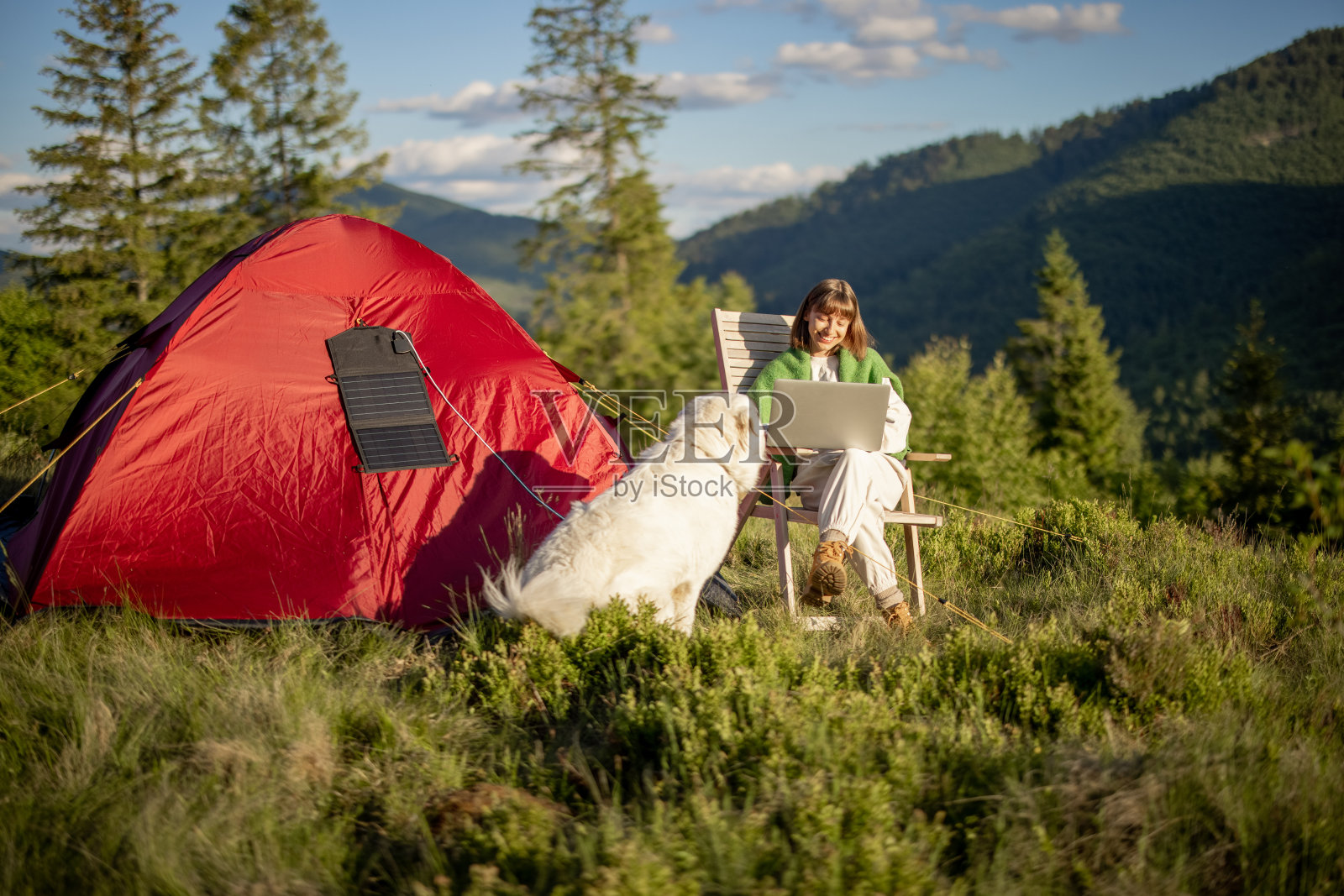 她在山上的营地用笔记本电脑工作照片摄影图片