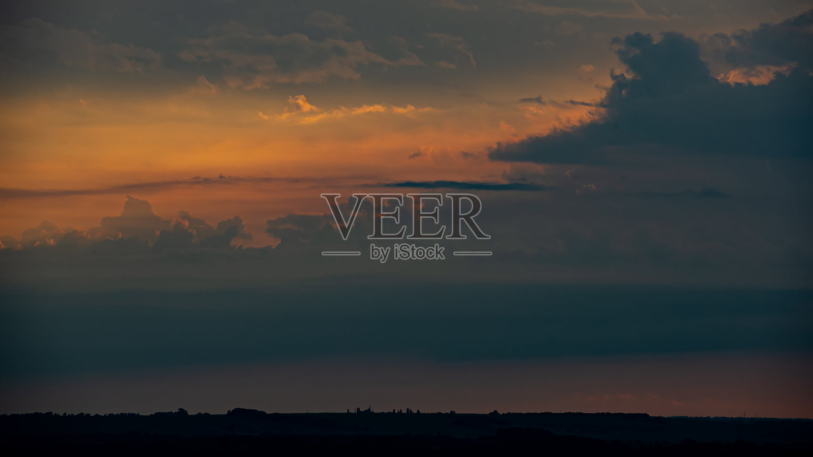 乌云背景下的夕阳。照片摄影图片