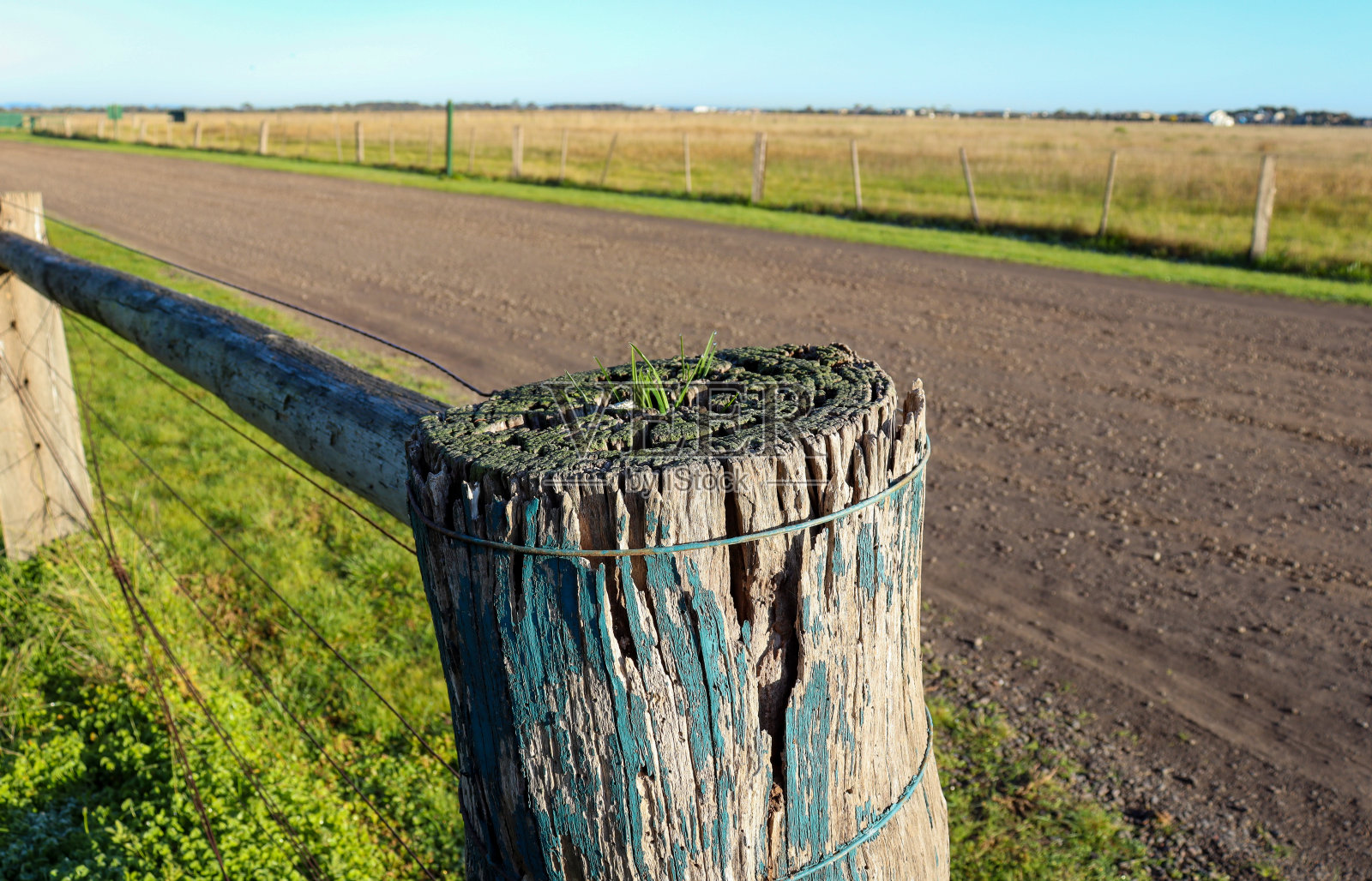 乡村道路上的田野上的篱笆照片摄影图片