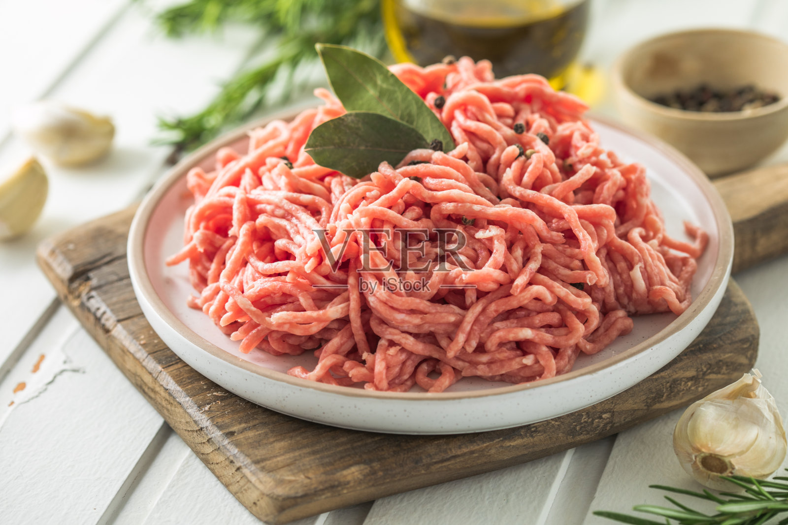 新鲜的生牛肉肉末与香草和迷迭香在木板上的一个明亮的背景,横幅,菜单,食谱文本的地方,顶部视图,照片摄影图片