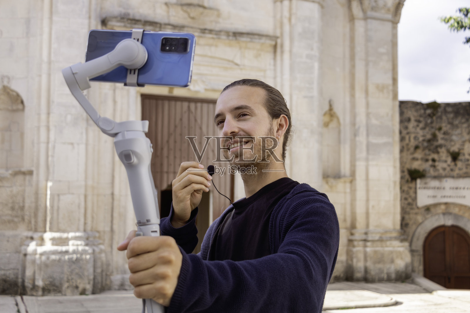 网红帅哥在户外用手机和万向节录像照片摄影图片