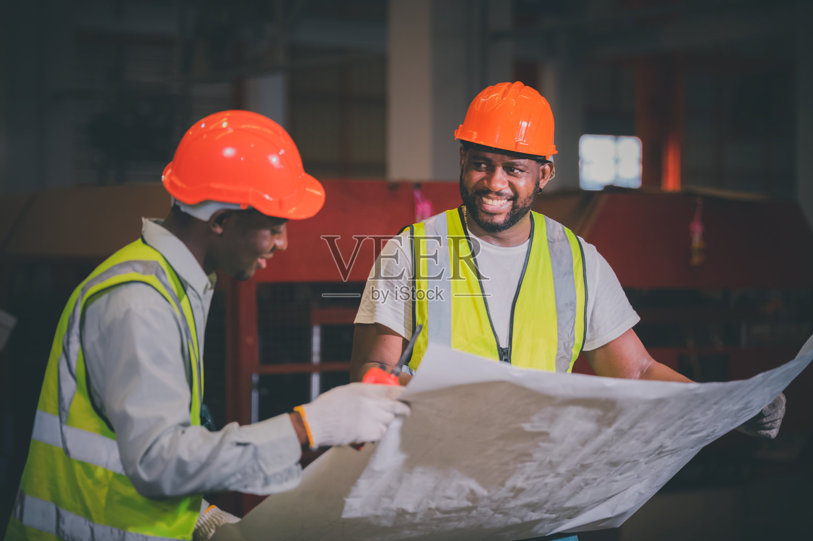 非裔美国黑人工人在工厂,两个重工业工程师站在钢铁金属制造厂和讨论。非裔美国黑人工业专家与技术员谈话照片摄影图片