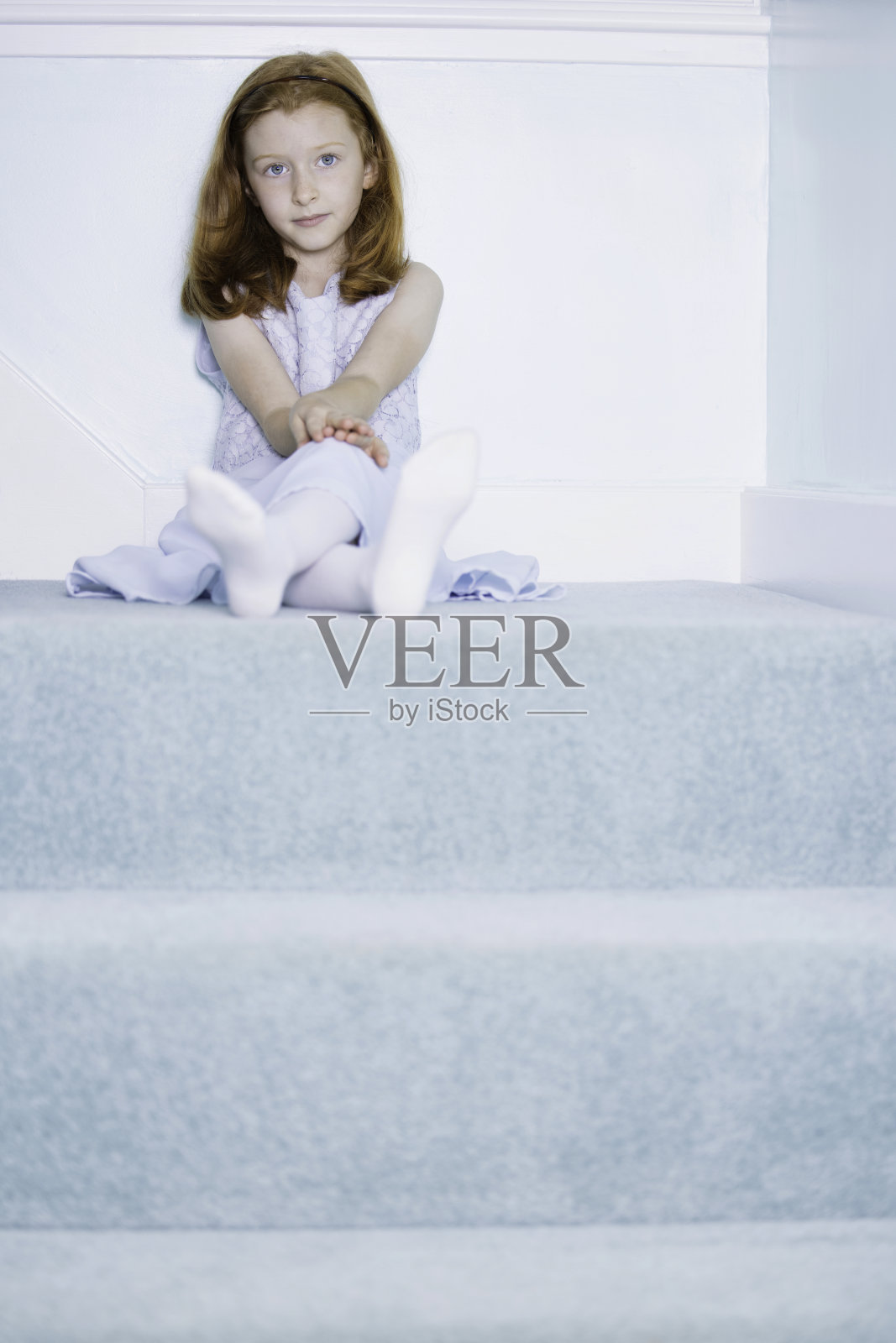 一个可爱的红褐色头发的女孩坐在楼梯上的照片照片摄影图片