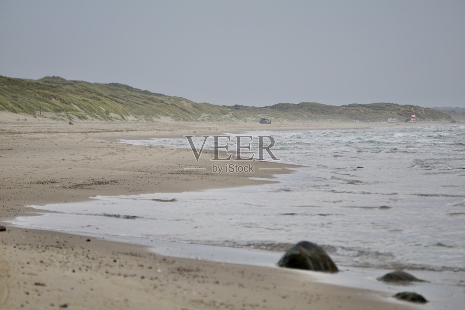 北海的海滩。偏振滤镜和深蓝色的天空与云。碧蓝的大海,碧波荡漾,雪白的沙滩。海鸥在大海的岩石上。乌云密布的天空。照片摄影图片