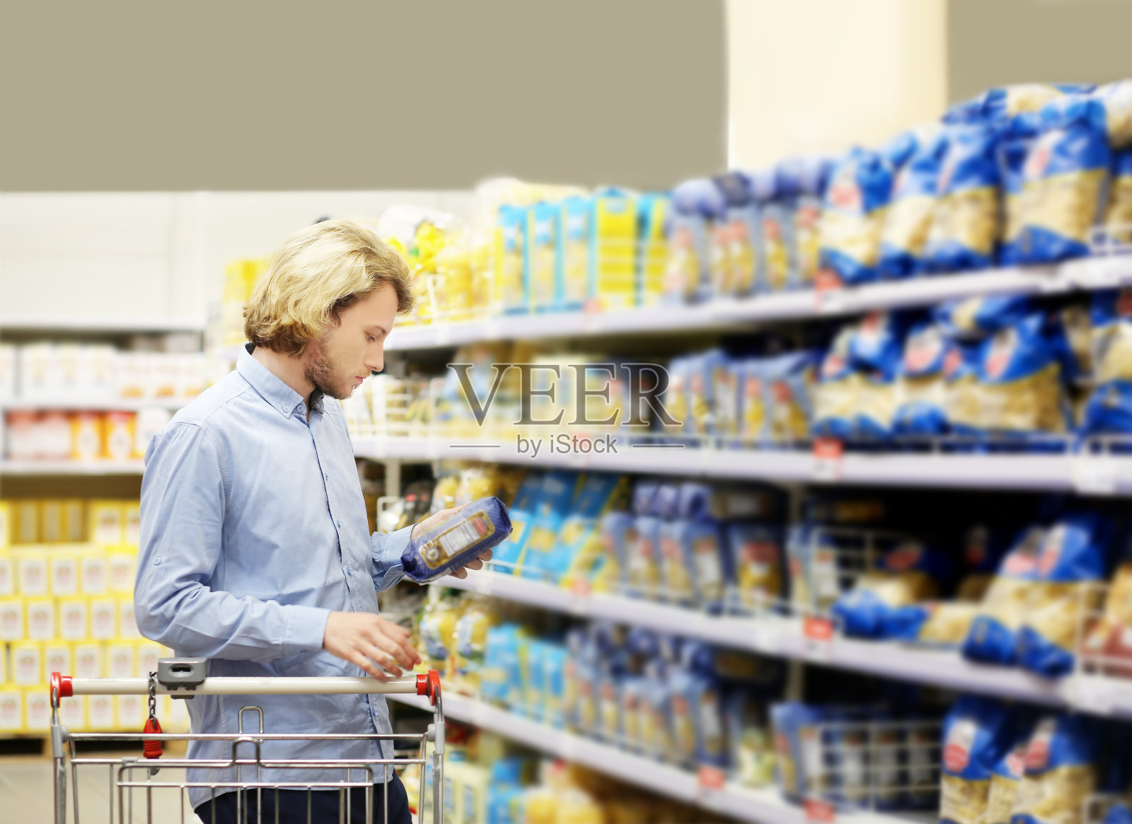 年轻人在超市购物,阅读商品信息照片摄影图片