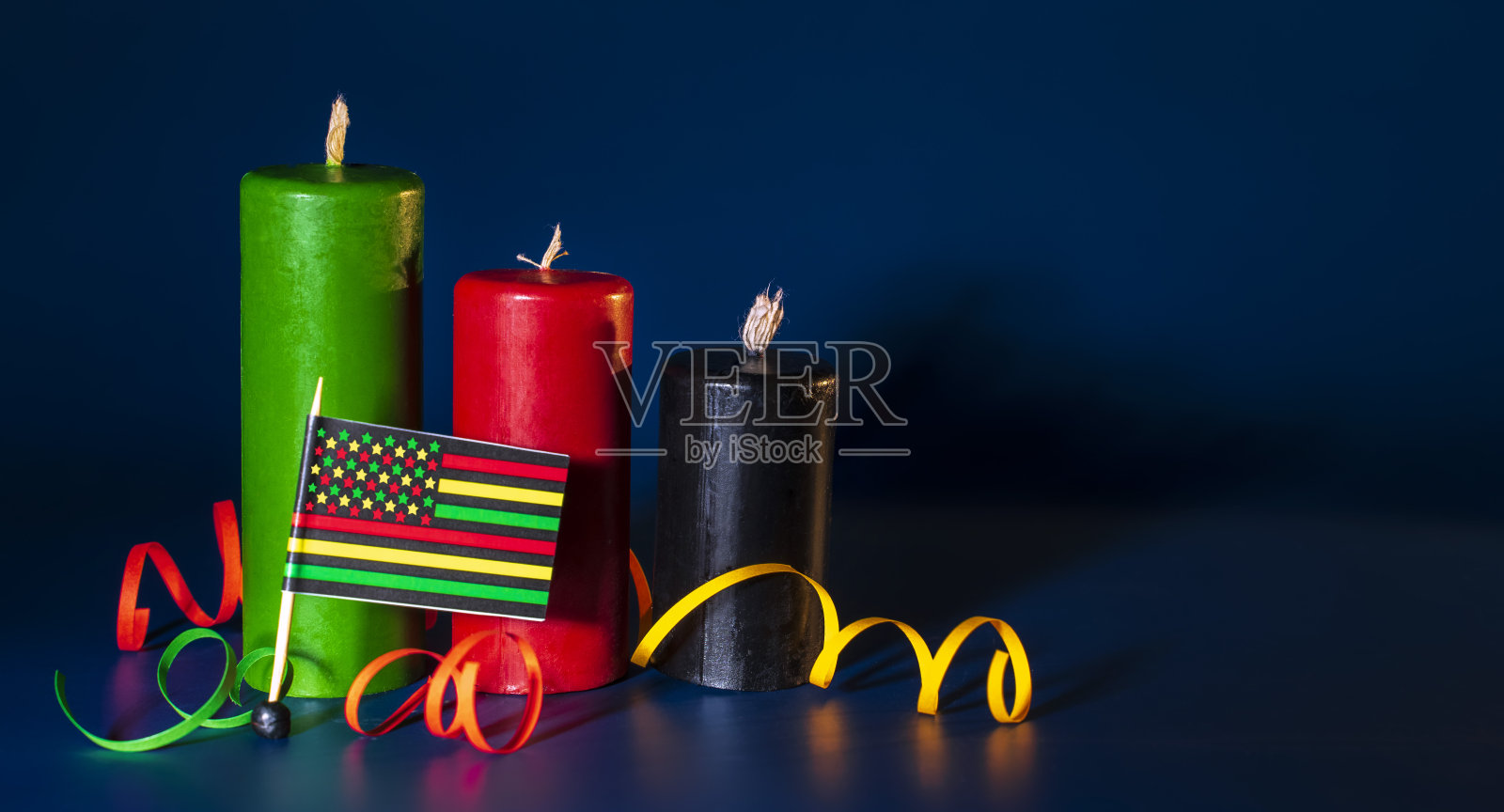 快乐宽扎概念与黑色,红色和绿色蜡烛在黑暗的背景,选择性聚焦照片摄影图片