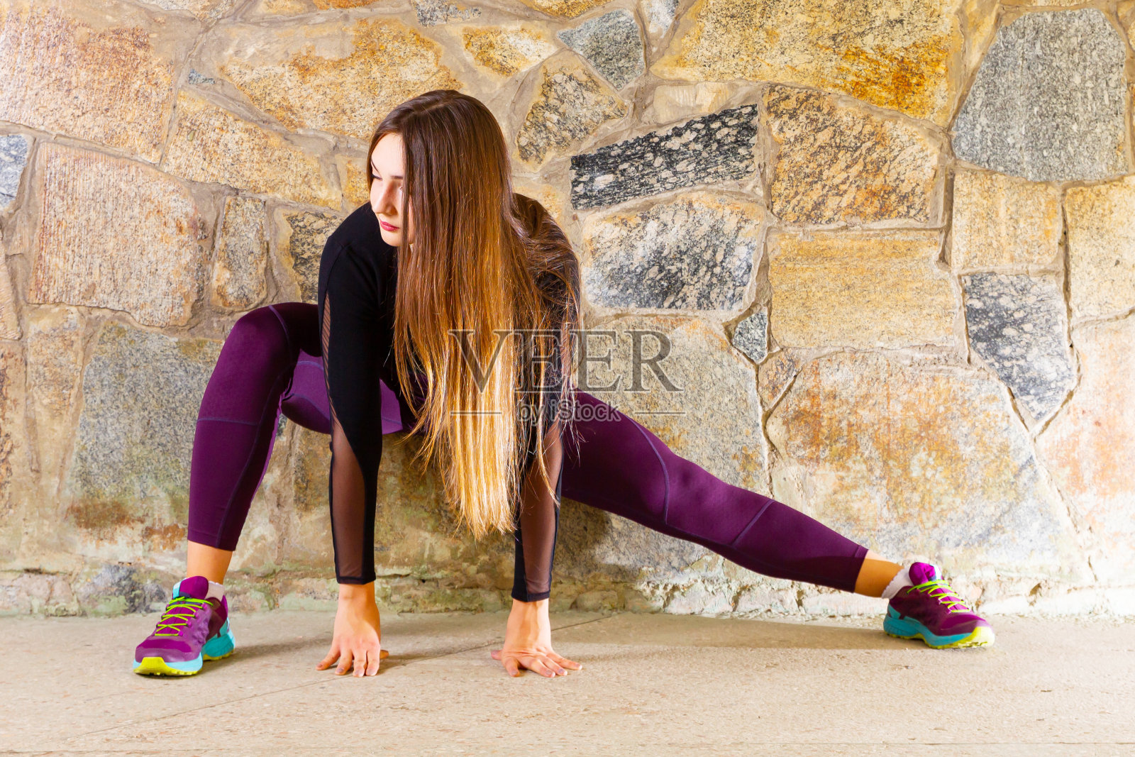 年轻的健身女性跑步前伸展腿。年轻的女运动员在户外训练前热身。运动和拉伸的概念照片摄影图片