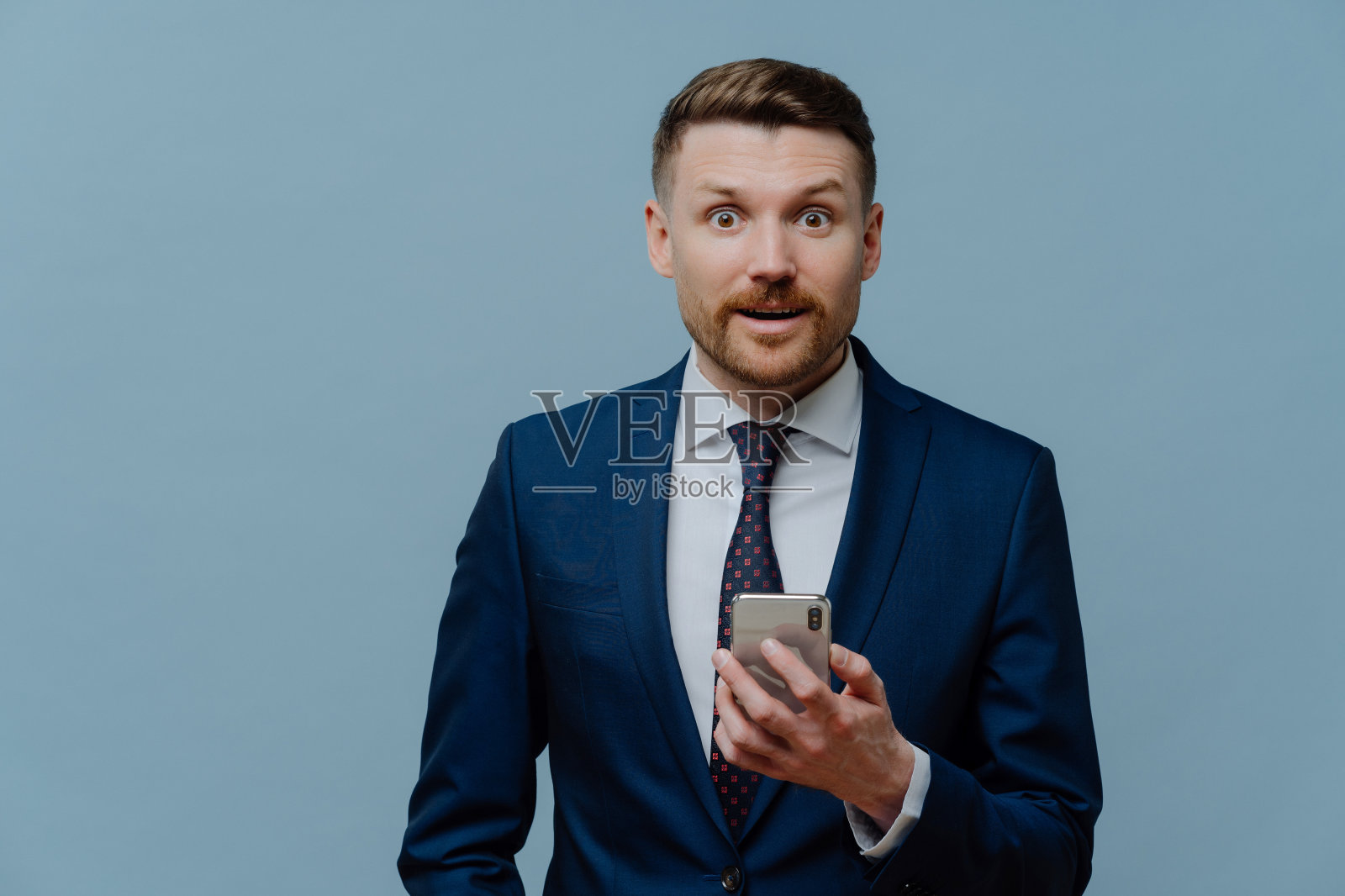 惊讶的商人在手机上阅读好消息照片摄影图片