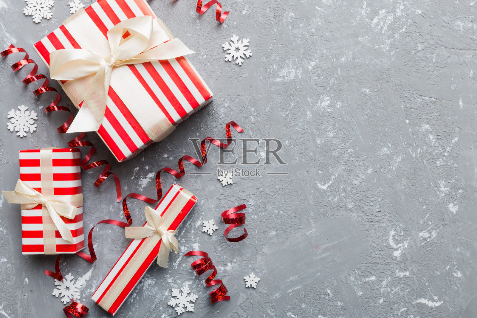 假日平铺礼品盒包装在五颜六色的纸和彩纸装饰彩带的背景。圣诞节,生日,情人节和销售概念,顶视图照片摄影图片