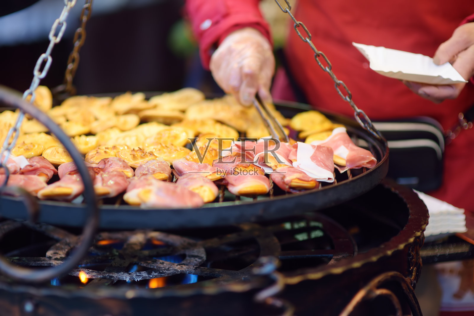 传统的波兰街头小吃oscypek是一种用腌羊奶和培根或果酱等不同原料制成的烤奶酪。克拉科夫圣诞市场上的oscypek烹饪。照片摄影图片