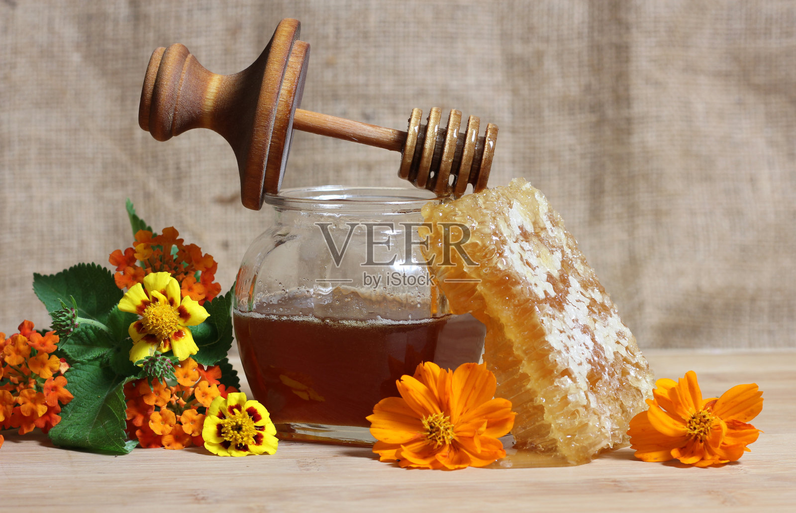 新鲜的蜂蜜与蜂窝和鲜花在质朴的厨房照片摄影图片