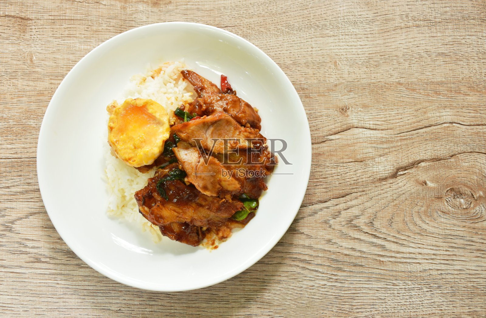 辣炒烧烤猪颈肉配上辣椒和罗勒叶咖喱,鸡蛋和米饭照片摄影图片