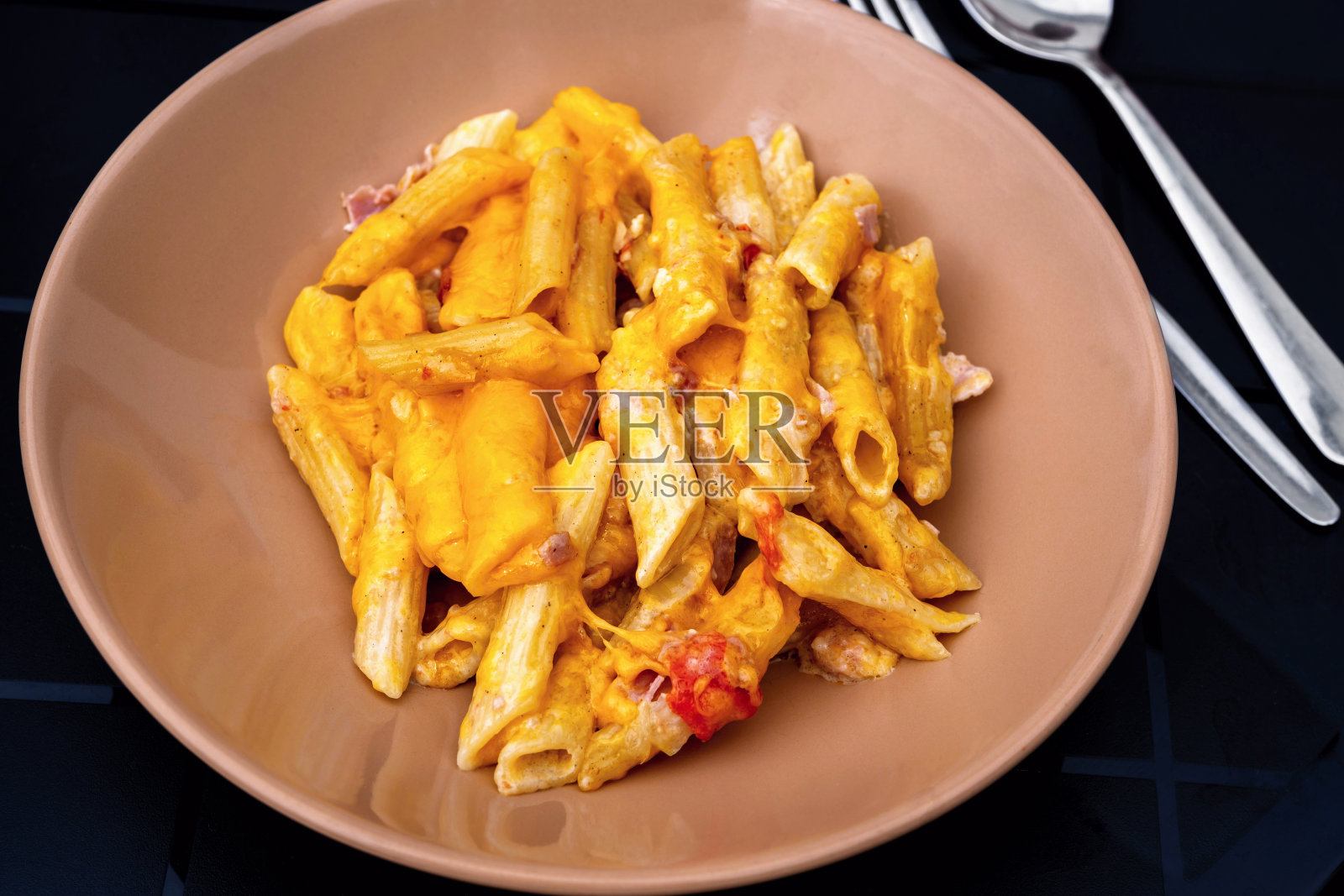 米色盘子上有番茄培根蛋奶沙司。照片摄影图片