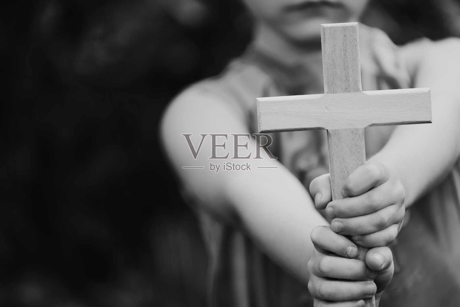 双手捧着木头十字架的小男孩照片摄影图片