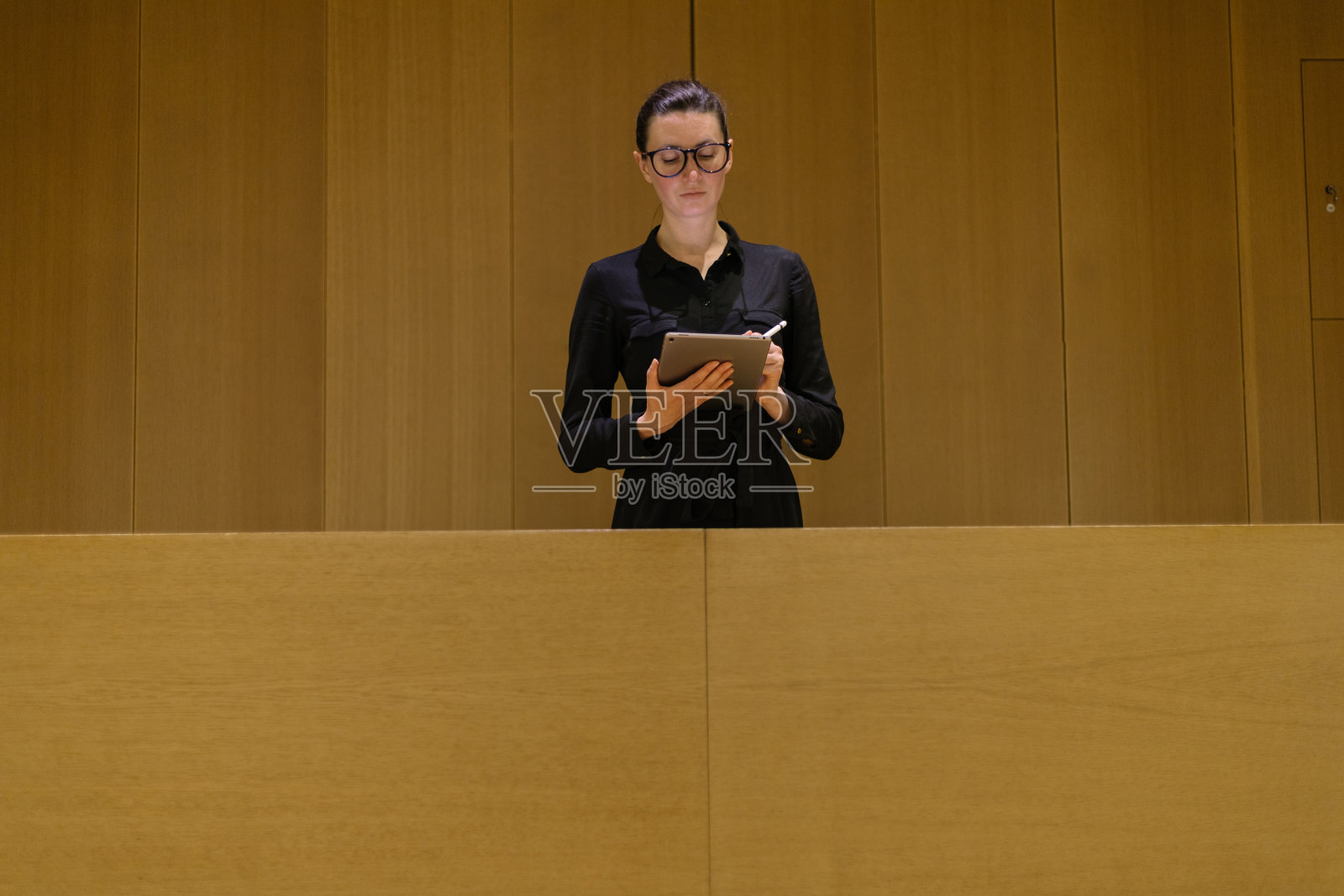 商务女性在极简办公室内使用平板电脑照片摄影图片