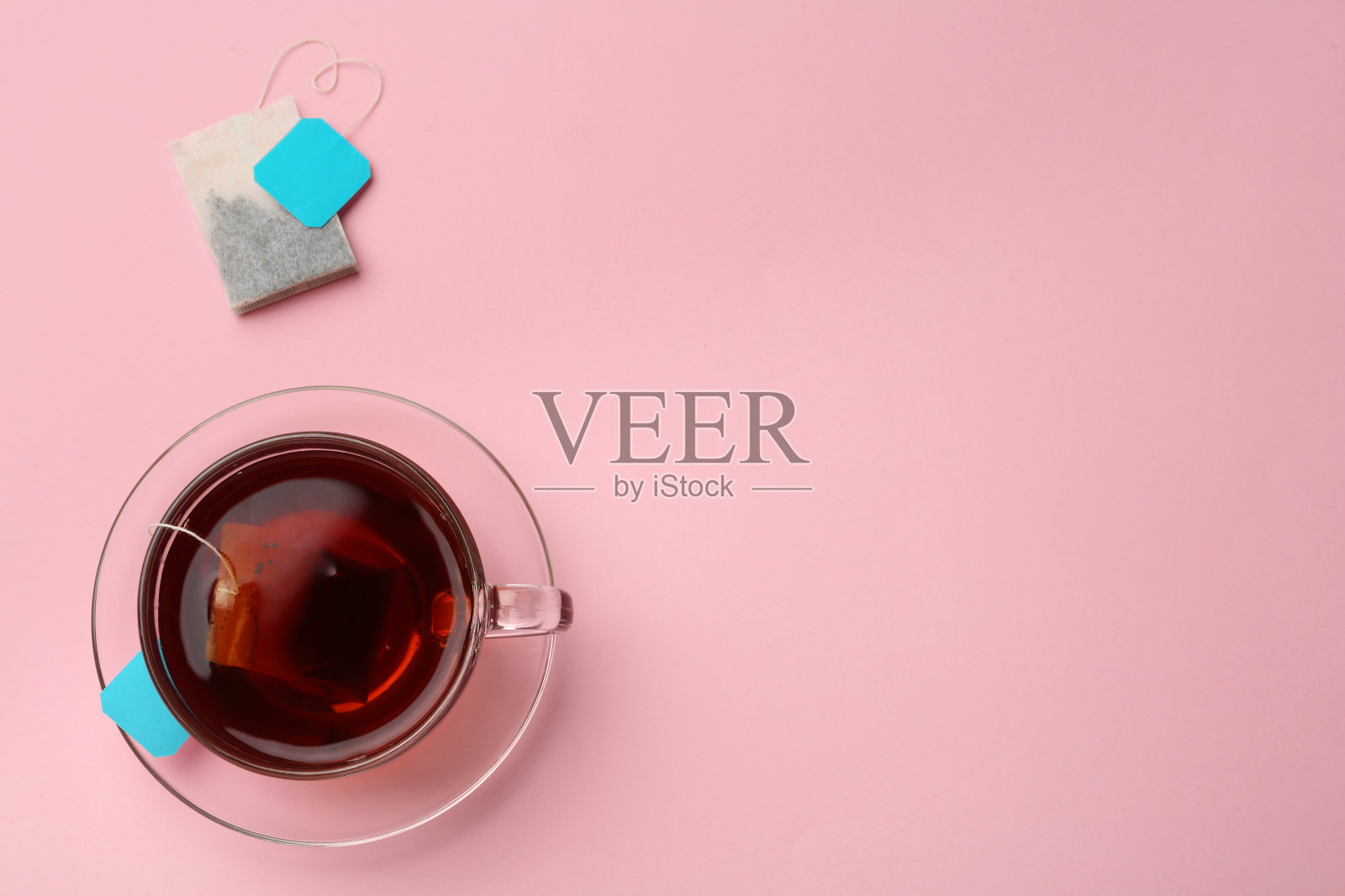 茶包和热饮杯在粉红色的背景,平放。空间的文本照片摄影图片