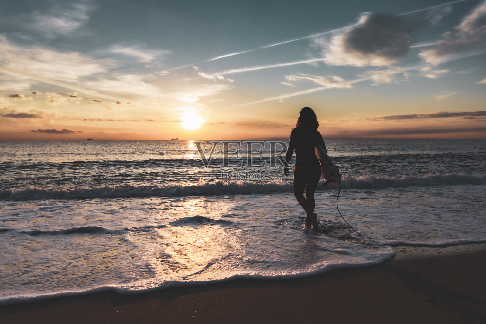 日落时沙滩上冲浪板的女人剪影照片摄影图片
