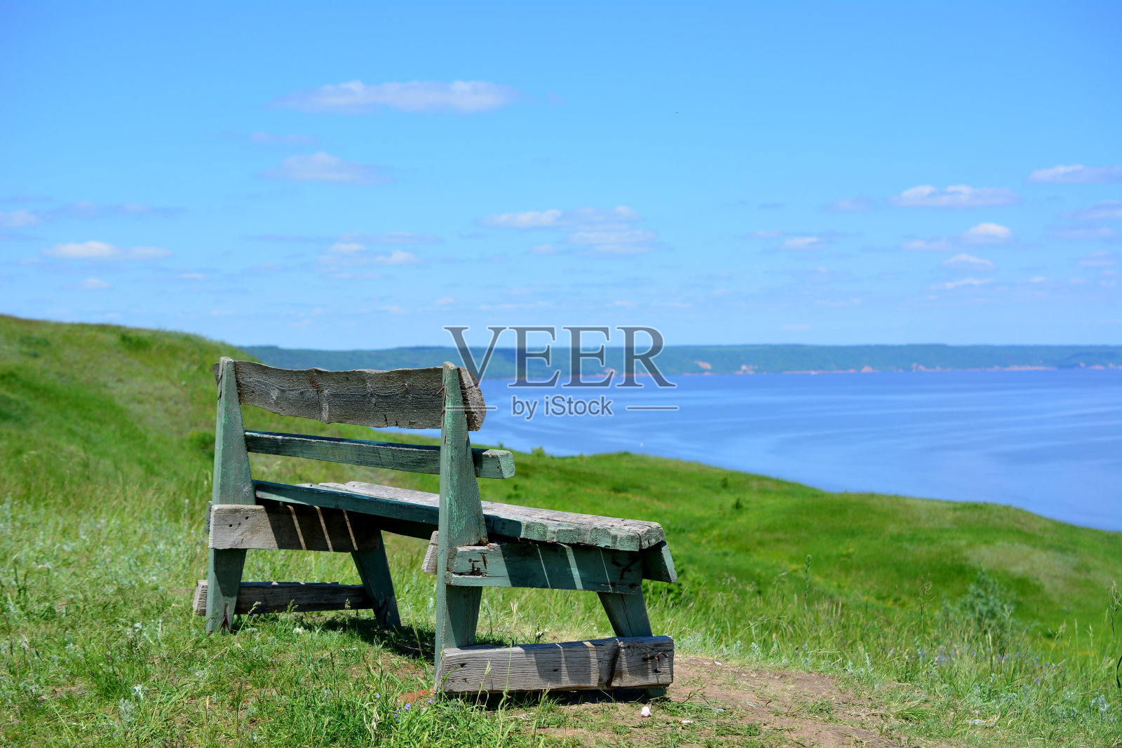 山顶上有一个孤零零的长凳,可以看到大海照片摄影图片