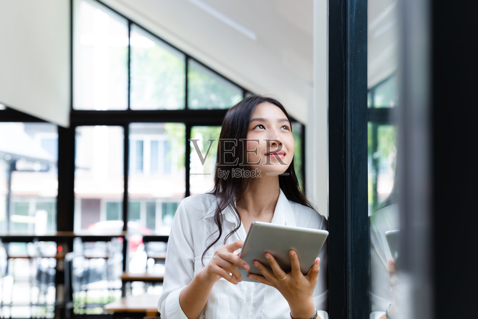 在办公室使用数字平板电脑的亚洲女商人。照片摄影图片