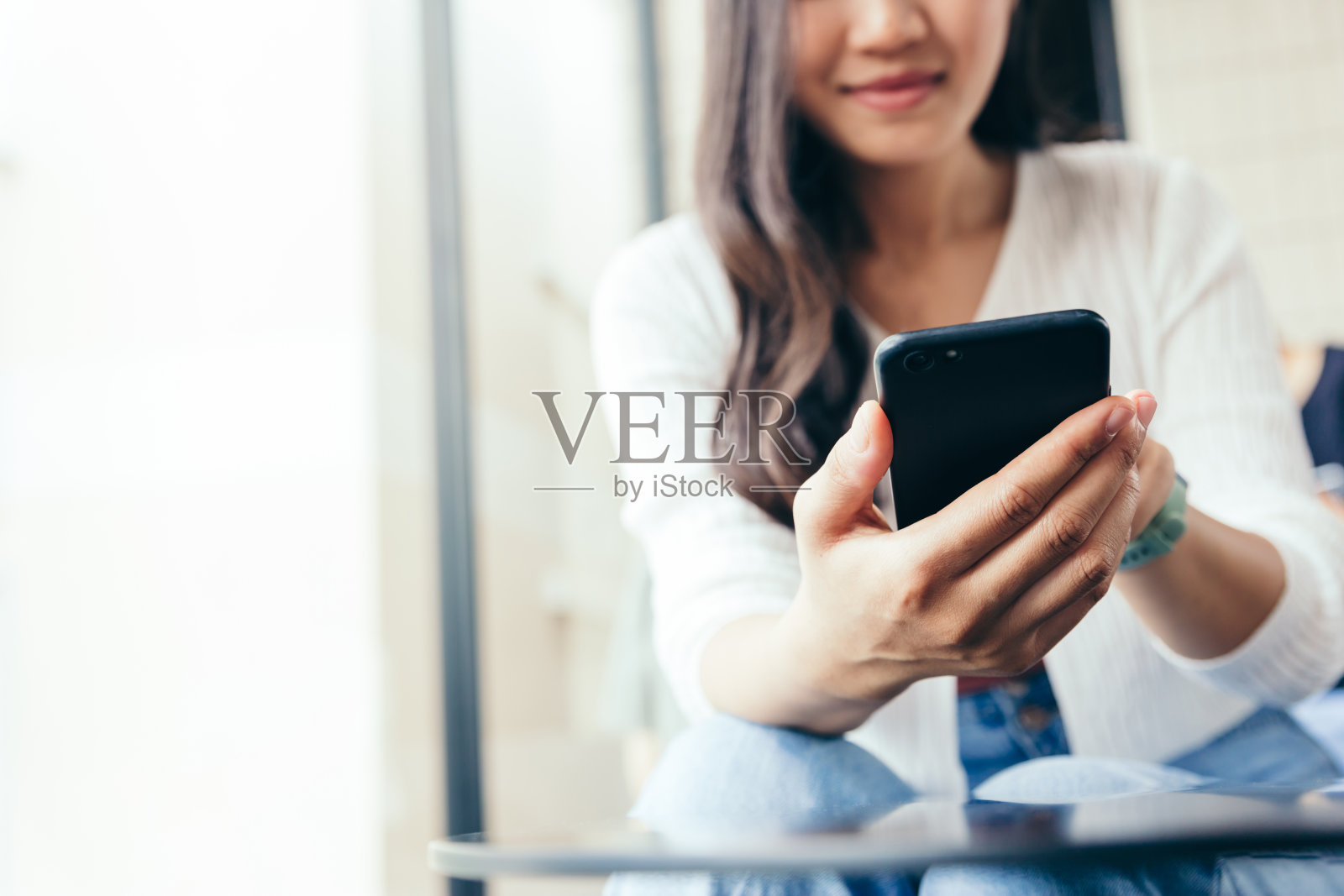 年轻女性在家里使用智能手机的手。照片摄影图片